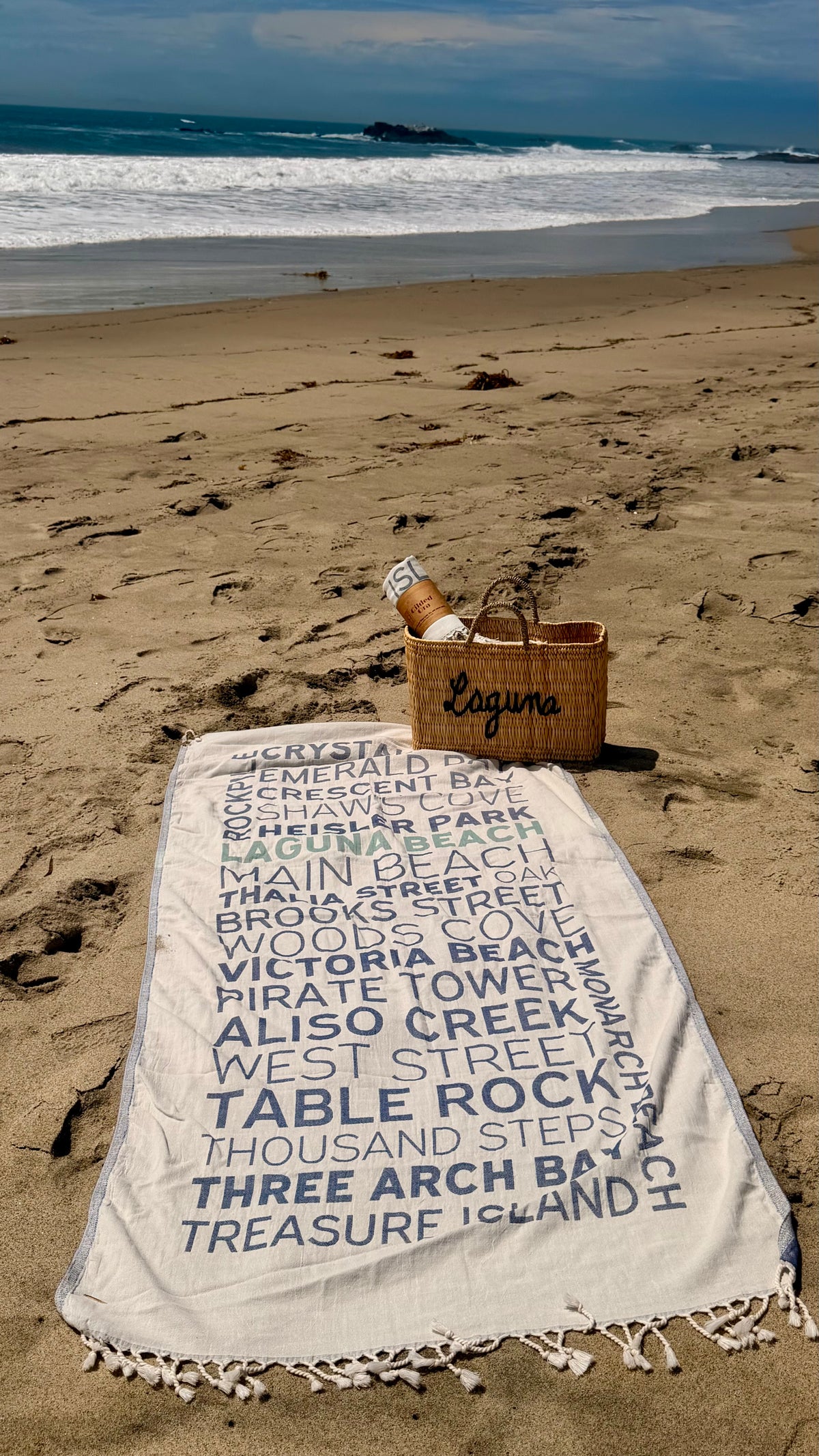Laguna Beaches Turkish cotton beach towel laid out on the sand by the ocean