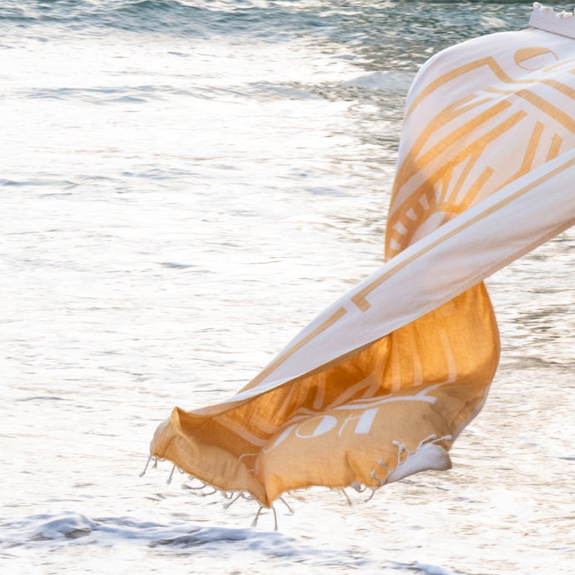 Golden Hour Turkish cotton beach towel draped in the ocean surf
