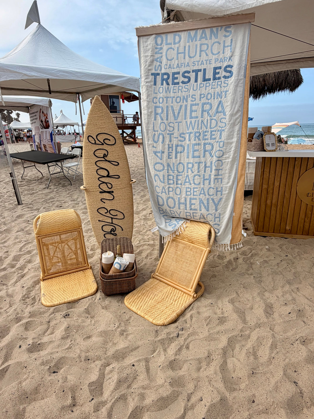 South OC Beaches Blue Turkish cotton beach towel displayed with a surfboard in a coastal beach setting in San Clemente 