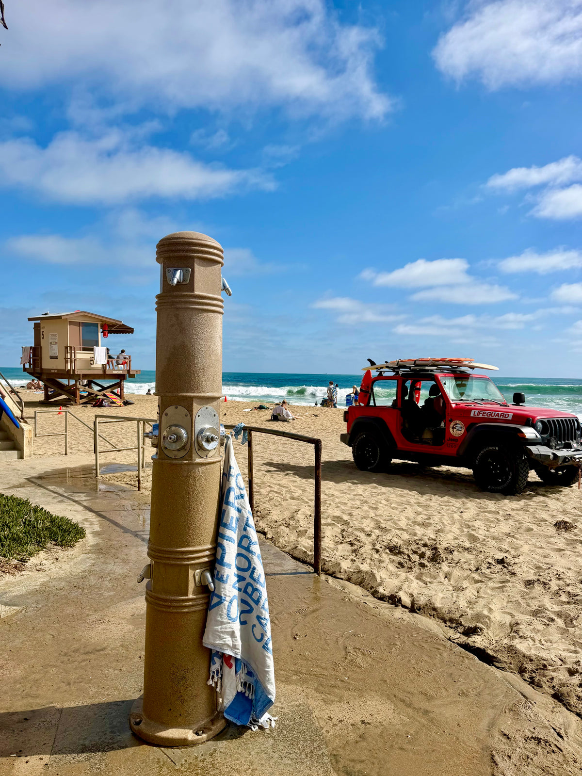 South OC Beaches Turkish cotton beach towel draped on a pole next to a lifeguard jeep at T-Street in San Clemente