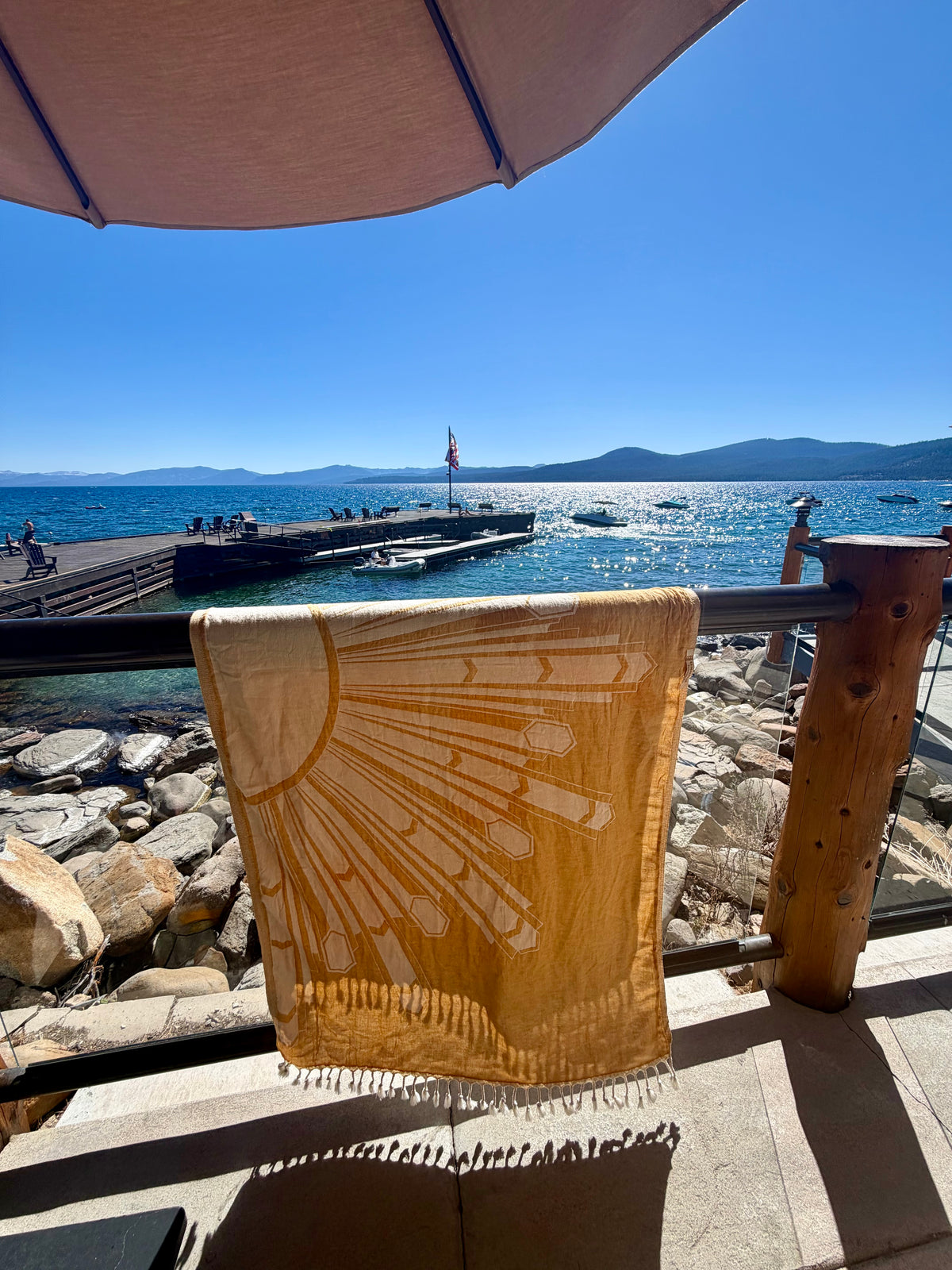 Deco Sunburst Turkish cotton beach towel hanging by the water in Lake Tahoe