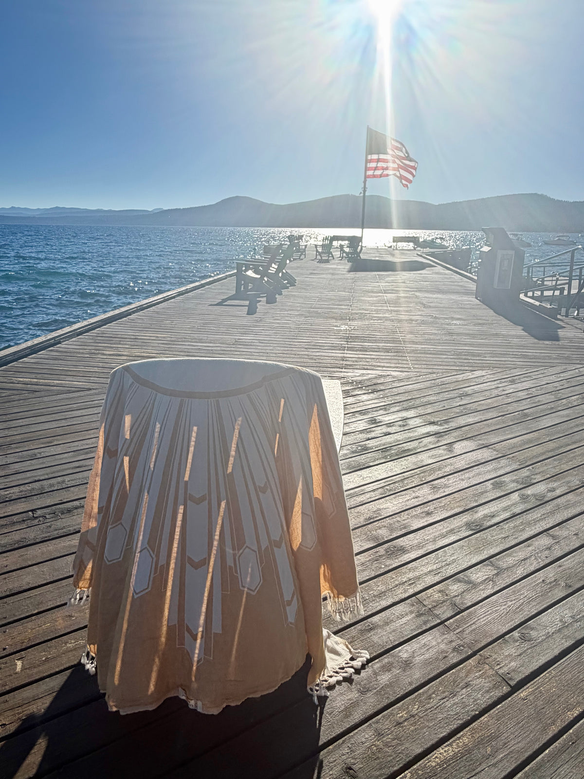 Deco Sunburst Turkish cotton beach towel draped on a chair by the ocean