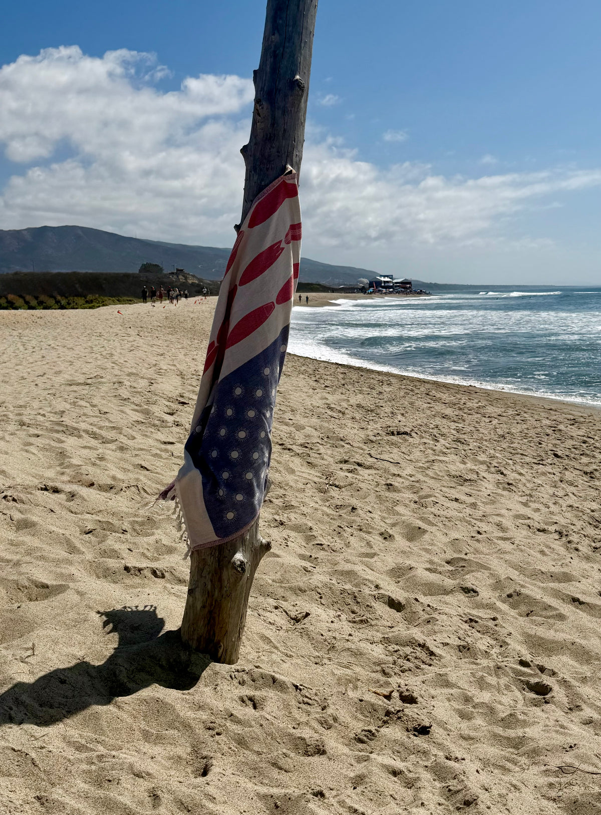 Americana Surfboard Turkish cotton beach towel wrapped around a wooden post at Trestles Beach in San Clemente