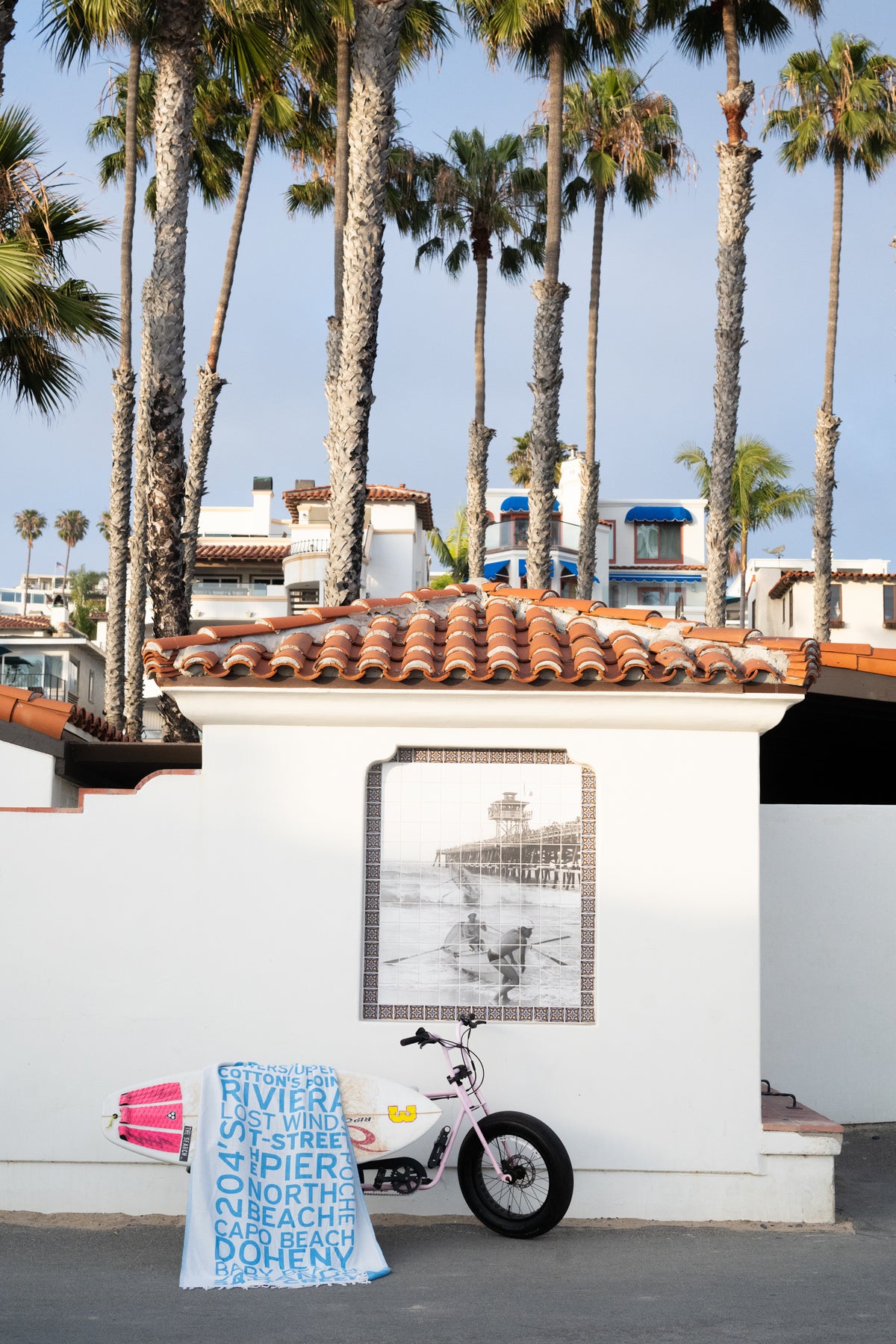 South OC Beaches Blue Turkish cotton beach towel styled in a coastal setting with palm trees in San Clemente